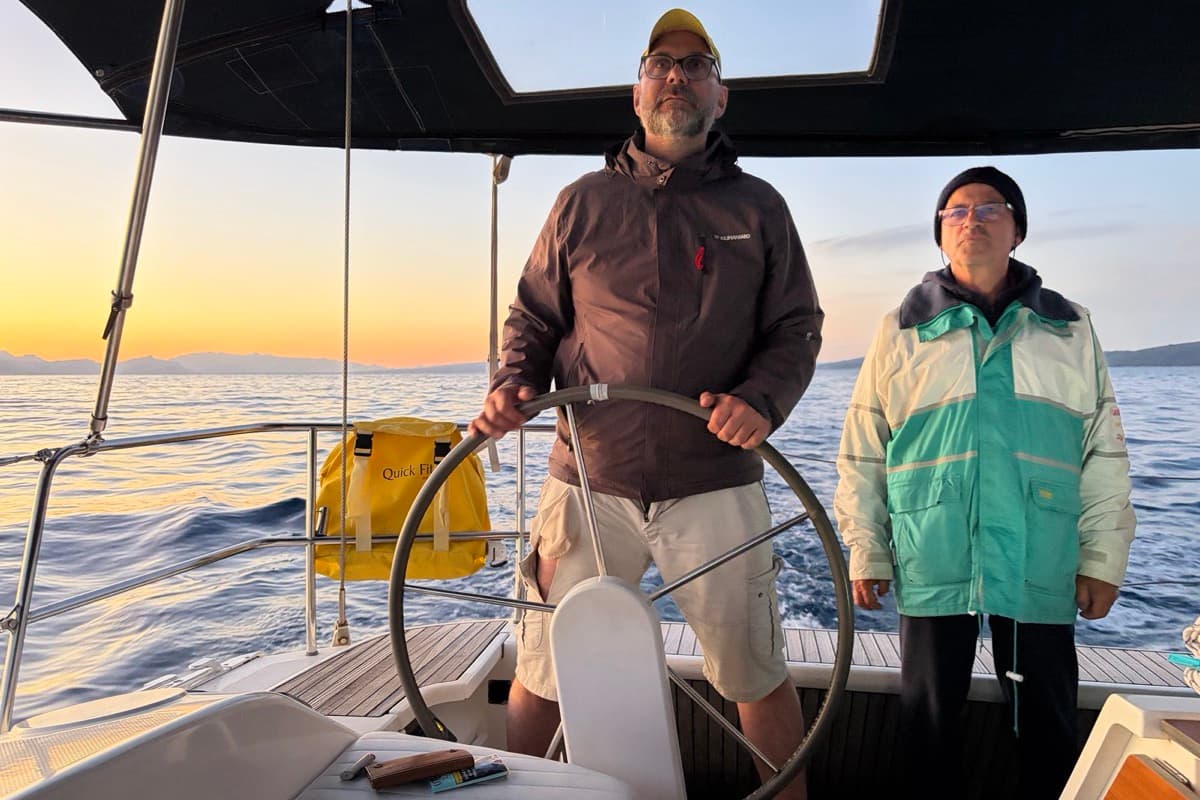 Zwei Männer der Crew am Steuer bei Sonnenuntergang